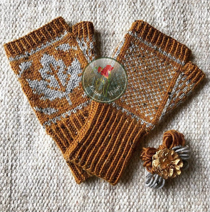 Pair of knitted mittens with a maple leaf pattern on a textured surface
