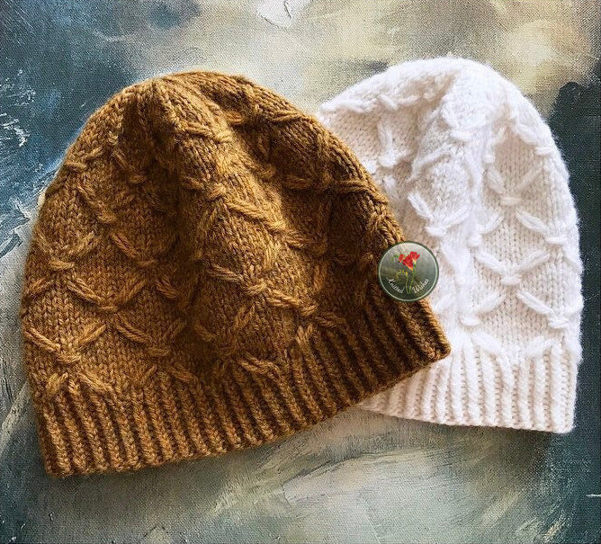 Yellow and white textured knitted hats on a painted surface