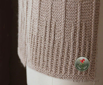 Close-up of a beige textured knitted scarf on a dark background