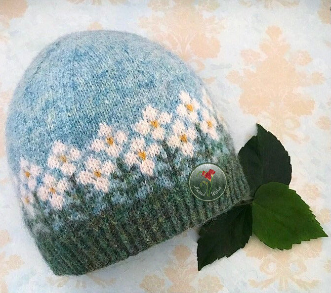Knitted colorwork hat with floral pattern on a floral background