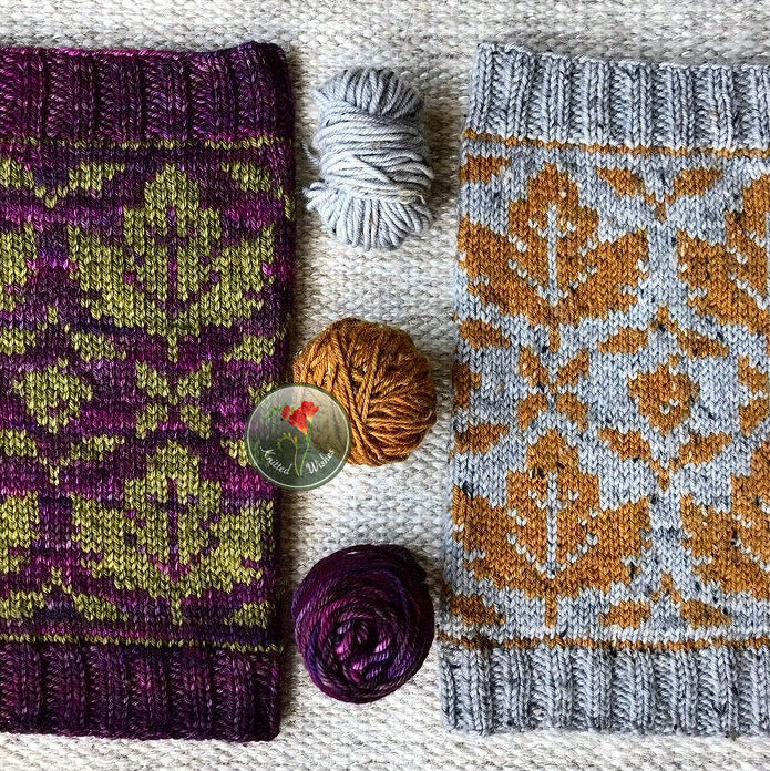 Two stranded colorwork knitted cowls with yarn  on a textured surface.