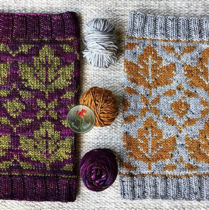 Two stranded colorwork knitted cowls with yarn  on a textured surface.
