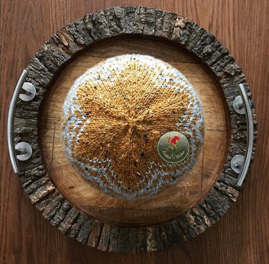 Knitted colorwork hat on a wooden tray.