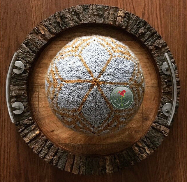 Knitted colorwork beanie on a wooden tray.