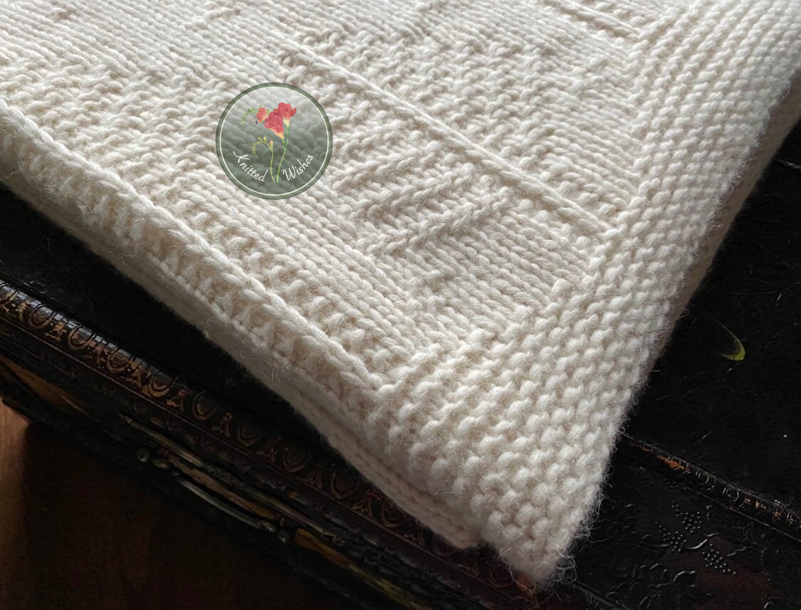 White knitted tree blanket on a dark surface