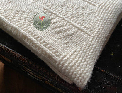 White knitted tree blanket on a dark surface