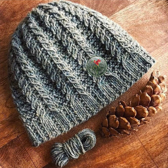 Knitted textured green beanie on a wooden surface.