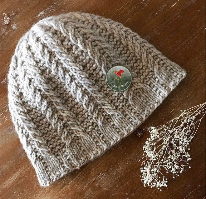 Knitted textured beanie on a wooden surface.