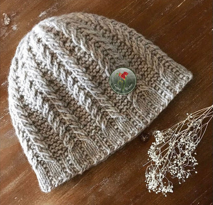 Knitted textured beanie on a wooden surface.
