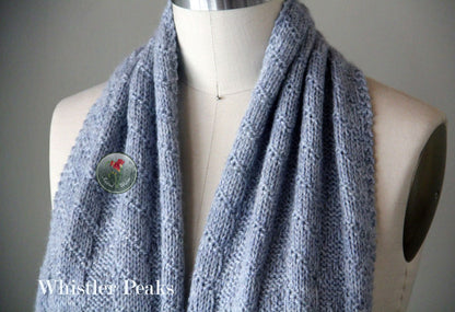 Blue textured knitted scarf on a mannequin.