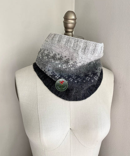 Knitted colorwork cowl with gradient design on a mannequin against a neutral background