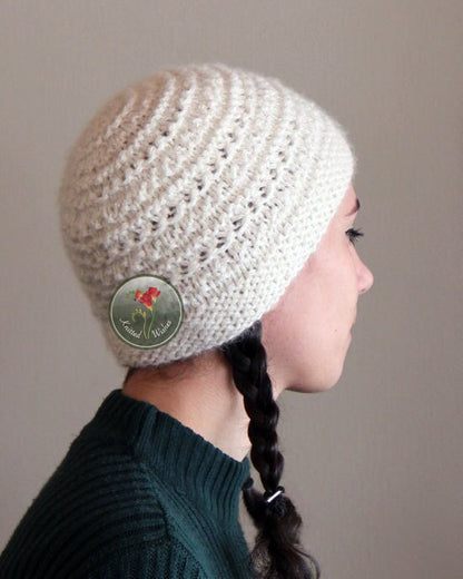 Person wearing a textured knit beanie with  on a plain background